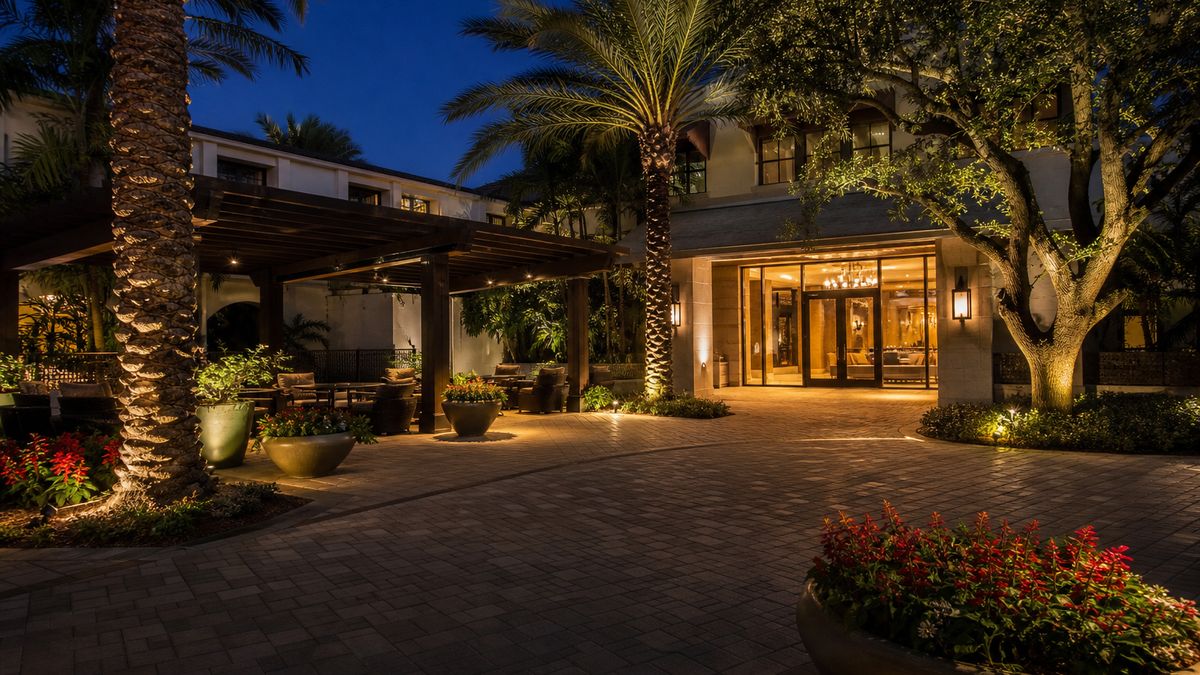 Hotel entrance and courtyard with warm landscape and accent lighting in Irving at night